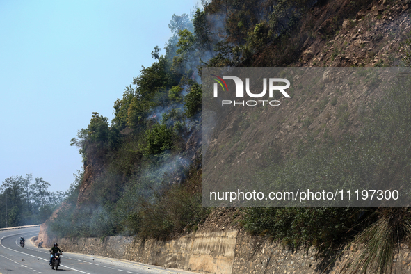 A forest fire is billowing smoke in a local community forest in Lalitpur, Central Nepal, on April 30, 2024. 