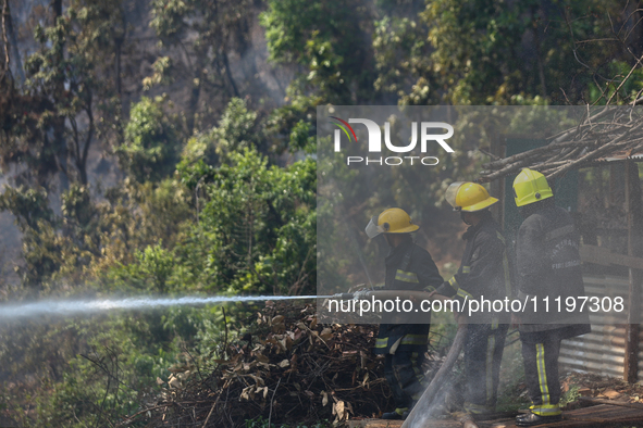 Nepali firefighters are attempting to douse a forest fire in Lalitpur District, Nepal, on April 30, 2024. 