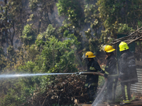 Nepali firefighters are attempting to douse a forest fire in Lalitpur District, Nepal, on April 30, 2024. (