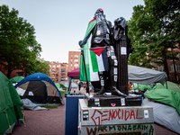 The statue of George Washington at the university bearing his name is surrounded by a Gaza solidarity encampment, Washington, DC, April 29,...