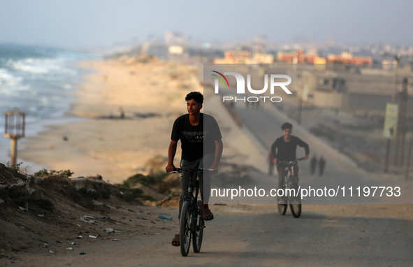 Palestinians are walking along the coastal Rashid road in the Nuseirat refugee camp in the central Gaza Strip on April 30, 2024, amid the on...