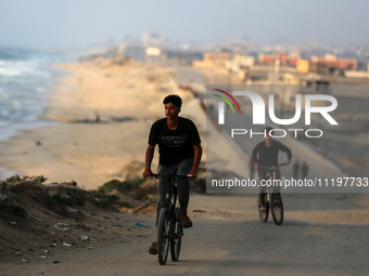 Palestinians are walking along the coastal Rashid road in the Nuseirat refugee camp in the central Gaza Strip on April 30, 2024, amid the on...