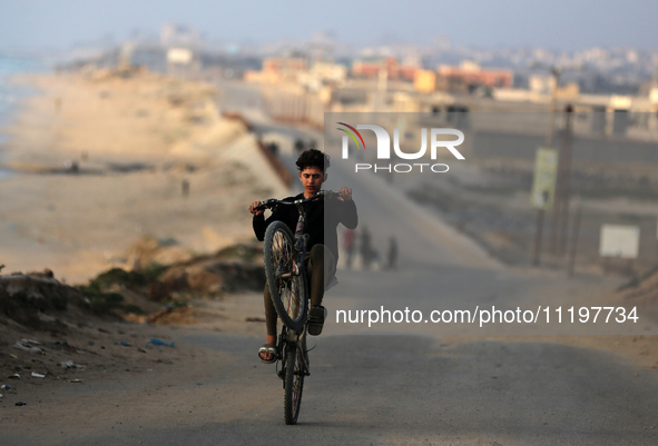 Palestinians are walking along the coastal Rashid road in the Nuseirat refugee camp in the central Gaza Strip on April 30, 2024, amid the on...