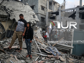 Palestinians are inspecting the damage to buildings after an Israeli bombardment in Deir Al-Balah, in the central Gaza Strip, on April 30, 2...