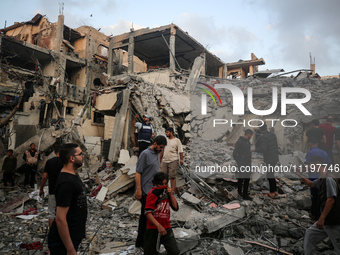 Palestinians are inspecting the damage to buildings after an Israeli bombardment in Deir Al-Balah, in the central Gaza Strip, on April 30, 2...