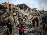 Palestinians are inspecting the damage to buildings after an Israeli bombardment in Deir Al-Balah, in the central Gaza Strip, on April 30, 2...