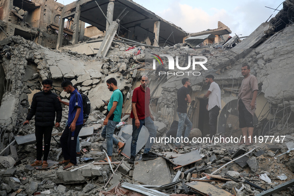 Palestinians are inspecting the damage to buildings after an Israeli bombardment in Deir Al-Balah, in the central Gaza Strip, on April 30, 2...