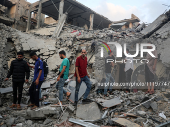 Palestinians are inspecting the damage to buildings after an Israeli bombardment in Deir Al-Balah, in the central Gaza Strip, on April 30, 2...