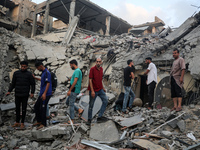 Palestinians are inspecting the damage to buildings after an Israeli bombardment in Deir Al-Balah, in the central Gaza Strip, on April 30, 2...