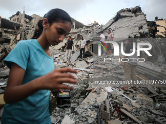 Palestinians are inspecting the damage to buildings after an Israeli bombardment in Deir Al-Balah, in the central Gaza Strip, on April 30, 2...