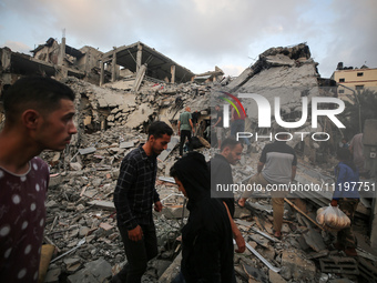 Palestinians are inspecting the damage to buildings after an Israeli bombardment in Deir Al-Balah, in the central Gaza Strip, on April 30, 2...