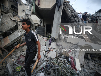 Palestinians are inspecting the damage to buildings after an Israeli bombardment in Deir Al-Balah, in the central Gaza Strip, on April 30, 2...