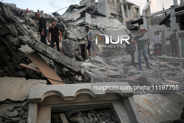 Palestinians are inspecting the damage to buildings after an Israeli bombardment in Deir Al-Balah, in the central Gaza Strip, on April 30, 2...