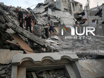 Palestinians are inspecting the damage to buildings after an Israeli bombardment in Deir Al-Balah, in the central Gaza Strip, on April 30, 2...