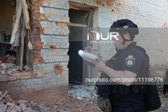 A police officer is documenting the destruction caused by the strike of Russian KAB guided bombs in Kharkiv, northeastern Ukraine, on April...