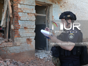 A police officer is documenting the destruction caused by the strike of Russian KAB guided bombs in Kharkiv, northeastern Ukraine, on April...