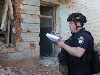 A police officer is documenting the destruction caused by the strike of Russian KAB guided bombs in Kharkiv, northeastern Ukraine, on April...