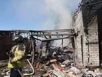 A rescuer is dealing with the aftermath of a Russian KAB aerial bomb attack in Kharkiv, northeastern Ukraine, on April 30, 2024. (