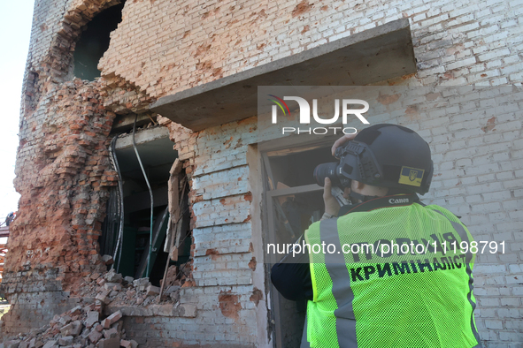 A police officer is documenting the destruction caused by the strike of Russian KAB guided bombs in Kharkiv, northeastern Ukraine, on April...