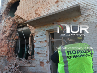 A police officer is documenting the destruction caused by the strike of Russian KAB guided bombs in Kharkiv, northeastern Ukraine, on April...