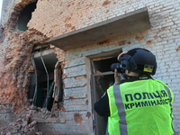 A police officer is documenting the destruction caused by the strike of Russian KAB guided bombs in Kharkiv, northeastern Ukraine, on April...