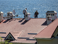 Men are checking the roof of a house after a fire caused by a Russian missile strike on the waterfront in Odesa, Ukraine, on April 30, 2024....