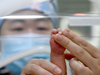 A nurse is giving a physical examination to a newborn in the neonatal intensive care unit of the No 4 Hospital in Handan, Hebei Province, No...