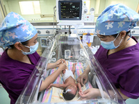 A nurse is caring for a child in the neonatal intensive care unit of the No 4 Hospital in Handan, Hebei Province, on May 1, 2024. (