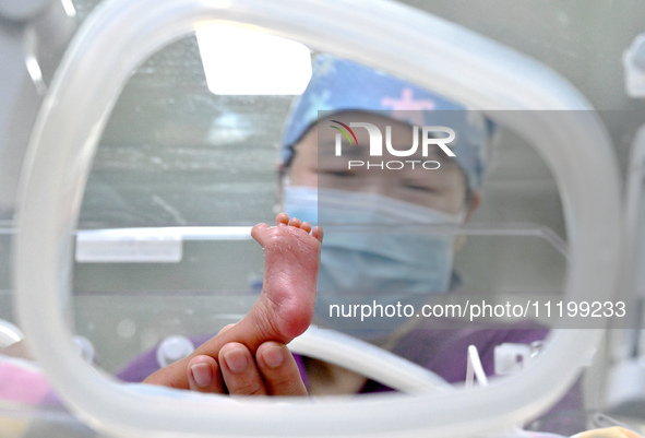 A nurse is giving a physical examination to a newborn in the neonatal intensive care unit of the No 4 Hospital in Handan, Hebei Province, No...