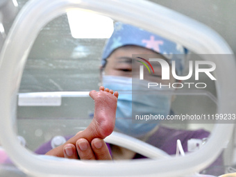 A nurse is giving a physical examination to a newborn in the neonatal intensive care unit of the No 4 Hospital in Handan, Hebei Province, No...