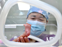 A nurse is giving a physical examination to a newborn in the neonatal intensive care unit of the No 4 Hospital in Handan, Hebei Province, No...