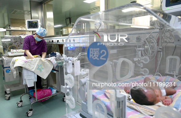 A nurse is caring for a child in the neonatal intensive care unit of the No 4 Hospital in Handan, Hebei Province, on May 1, 2024. 