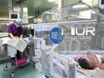 A nurse is caring for a child in the neonatal intensive care unit of the No 4 Hospital in Handan, Hebei Province, on May 1, 2024. (