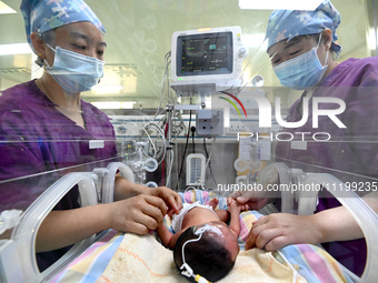 A nurse is caring for a child in the neonatal intensive care unit of the No 4 Hospital in Handan, Hebei Province, on May 1, 2024. (