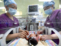 A nurse is caring for a child in the neonatal intensive care unit of the No 4 Hospital in Handan, Hebei Province, on May 1, 2024. (