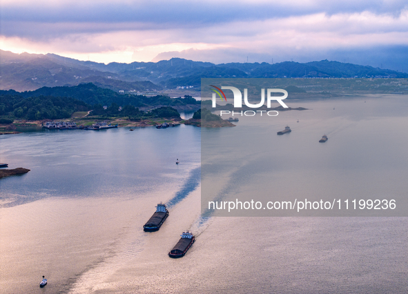 Transport ships are sailing in the waters in front of a dam in the Three Gorges reservoir area of the Yangtze River in Zigui County, Yichang...