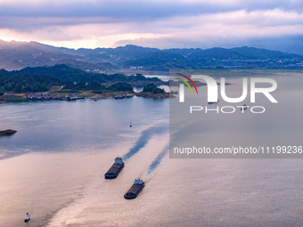 Transport ships are sailing in the waters in front of a dam in the Three Gorges reservoir area of the Yangtze River in Zigui County, Yichang...