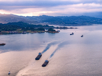 Transport ships are sailing in the waters in front of a dam in the Three Gorges reservoir area of the Yangtze River in Zigui County, Yichang...