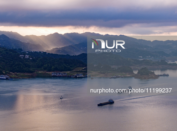 Transport ships are sailing in the waters in front of a dam in the Three Gorges reservoir area of the Yangtze River in Zigui County, Yichang...