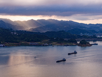 Transport ships are sailing in the waters in front of a dam in the Three Gorges reservoir area of the Yangtze River in Zigui County, Yichang...