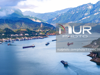 Transport ships are sailing in the waters in front of a dam in the Three Gorges reservoir area of the Yangtze River in Zigui County, Yichang...