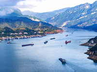 Transport ships are sailing in the waters in front of a dam in the Three Gorges reservoir area of the Yangtze River in Zigui County, Yichang...