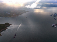 Transport ships are sailing in the waters in front of a dam in the Three Gorges reservoir area of the Yangtze River in Zigui County, Yichang...