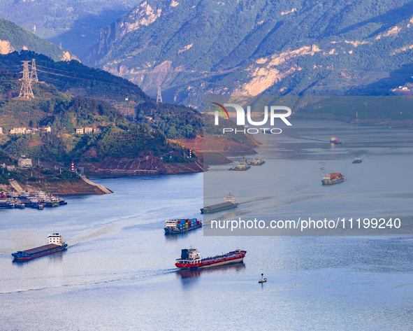 Transport ships are sailing in the waters in front of a dam in the Three Gorges reservoir area of the Yangtze River in Zigui County, Yichang...