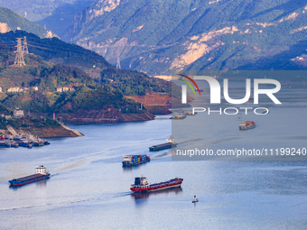 Transport ships are sailing in the waters in front of a dam in the Three Gorges reservoir area of the Yangtze River in Zigui County, Yichang...