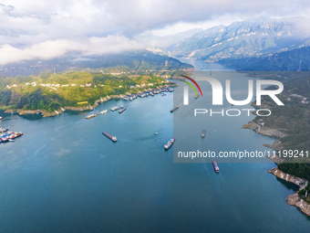 Transport ships are sailing in the waters in front of a dam in the Three Gorges reservoir area of the Yangtze River in Zigui County, Yichang...