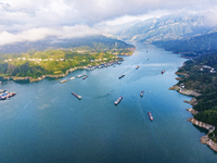 Transport ships are sailing in the waters in front of a dam in the Three Gorges reservoir area of the Yangtze River in Zigui County, Yichang...