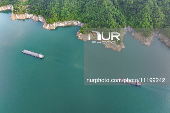 Transport ships are sailing in the waters in front of a dam in the Three Gorges reservoir area of the Yangtze River in Zigui County, Yichang...