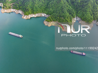 Transport ships are sailing in the waters in front of a dam in the Three Gorges reservoir area of the Yangtze River in Zigui County, Yichang...