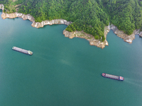 Transport ships are sailing in the waters in front of a dam in the Three Gorges reservoir area of the Yangtze River in Zigui County, Yichang...